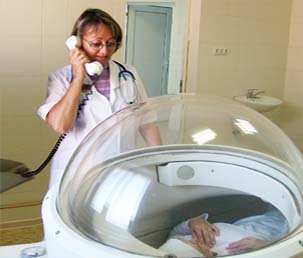 Врач разговаривает с пациентом при лечении кислородом в барокамере Центра лазерной медицины в Краснодаре